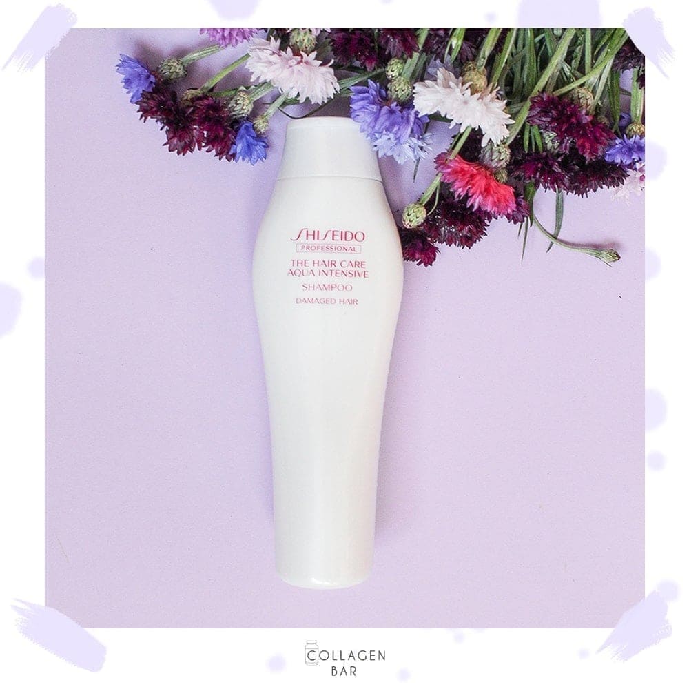 Шампунь Shiseido Aqua Intensive на фіолетовому фоні з польовими квітами у верхньому правому кутку.